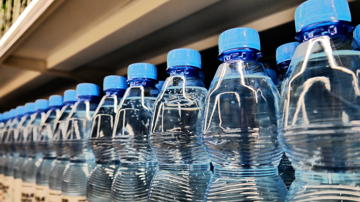 Varias botellas individuales de agua purificada de 500 ml acomodadas para invitados, frías y con gotas de condensación.